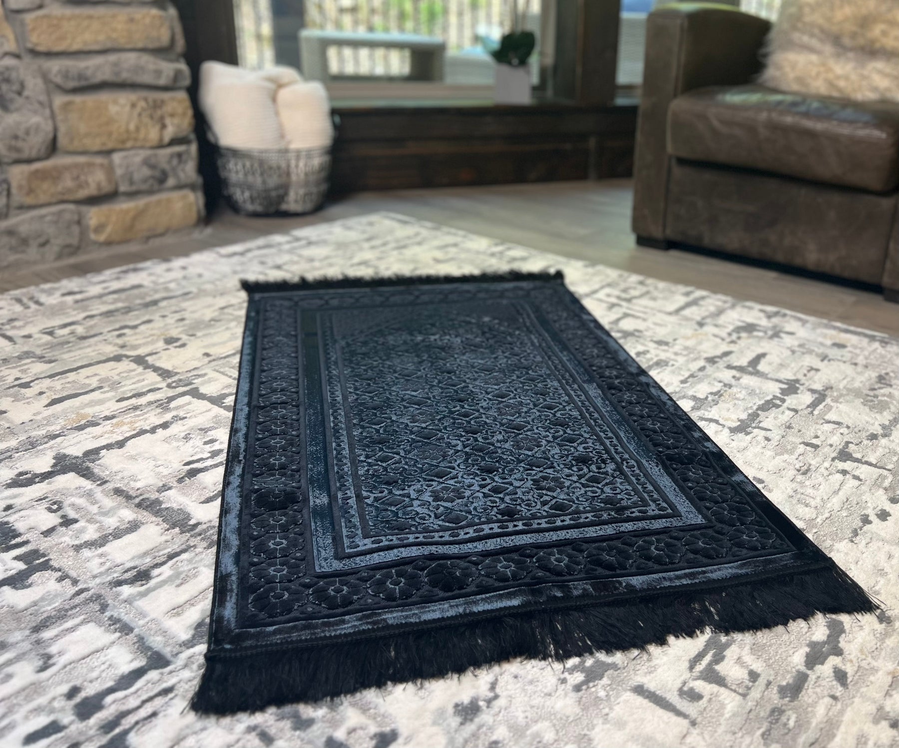 black prayer rug with luxurious sheen on the floor in a cozy home with neutral tones